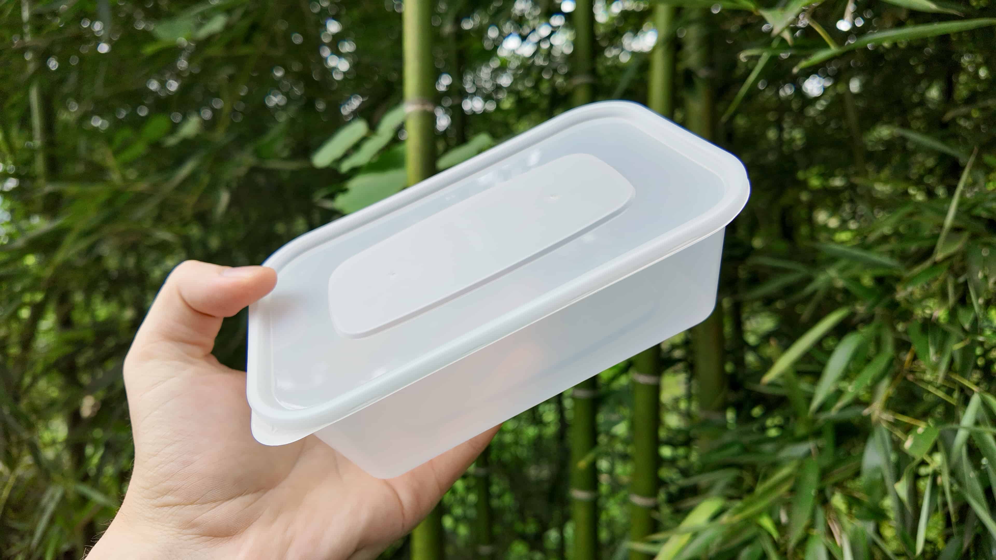 A hand holding a clear PP5 plastic container